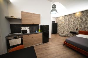 a bedroom with a bed and a kitchen with a microwave at Chivasso centro - Garden Apartments in Chivasso