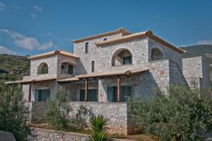 a stone house with windows on a hill at Melitsina Village Hotel in Kardamyli