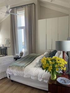 a bedroom with a bed with a vase of flowers on a table at Blissful Barons View in Plettenberg Bay