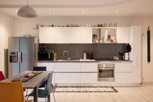 a kitchen with white cabinets and a table with chairs at Art-inn in San Vendemiano
