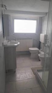 a bathroom with a toilet and a sink and a window at Ca' de' Mari at Como - Switzerland - Private Parking - Self Check-In in Faloppio