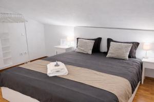 a bedroom with a large bed with a white bag on it at Lo Exclusive Lisboa - Apartament with terrace and golf view in Charneca