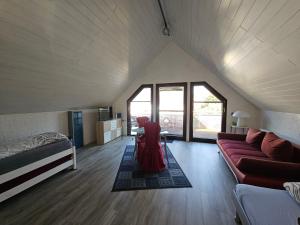 a room with a couch and a bed in a attic at 2 Ferienwohnungen Klenk in Gruibingen