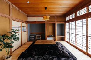 a bedroom with a large bed in a room with windows at 松本市の一棟貸しのプライベート邸宅 in Matsumoto
