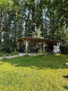a wooden pavilion in a yard with trees at Chill & Nature in Nargis