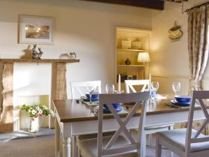 a dining room with a table and chairs at Mont Stewart Cottage in Whiting Bay