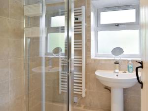 a bathroom with a shower and a sink at Mont Stewart Cottage in Whiting Bay +12 photos