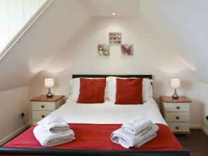 a bedroom with a bed with towels on it at Mont Stewart Cottage in Whiting Bay