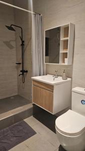 a bathroom with a toilet and a sink and a shower at The Basileia Court in Janman +16 photos