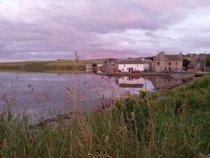 a large body of water with buildings and a town at 2 The Noust Self Catering in Saint Margarets Hope