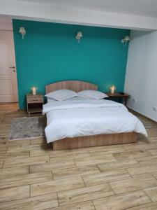 a bedroom with a large bed with a blue wall at Casa Muresan in Cluj-Napoca