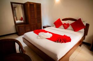 a bedroom with a bed with red and white pillows at Explora Lodge in Arusha +42 photos