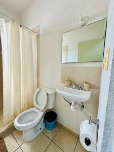 a bathroom with a toilet and a sink and a mirror at Casa completa en Acapulco in Acapulco +4 photos