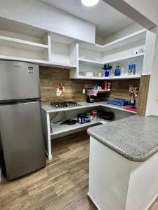 a kitchen with a refrigerator and a counter top at Casa completa en Acapulco in Acapulco