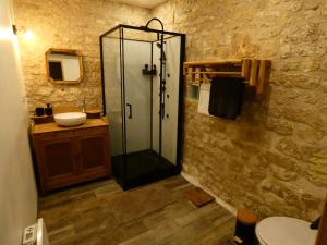 a bathroom with a glass shower and a sink at Gîte Val de Loire Le Puits in Loudun +9 photos