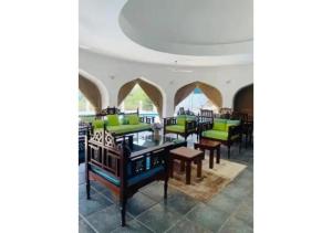 a restaurant with tables and chairs in a room at Mango Villa Mtwapa in Mtwapa