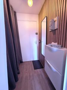 a hallway with a white door and a mirror at Appartement tout confort très proche mer in Villers-sur-Mer