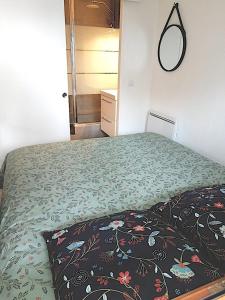 a bedroom with a bed with a flowered bedspread at Appartement tout confort très proche mer in Villers-sur-Mer