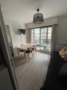 a living room with a table and a table and chairs at Appartement tout confort très proche mer in Villers-sur-Mer