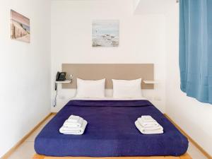 a bedroom with a bed with a purple blanket at Island Guesthouse in Il-Gżira