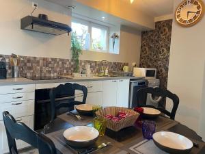 a kitchen with a table with chairs and a tableasteryasteryasteryasteryasteryastery at Vert Bocage à Bâlines in Balines +5 photos