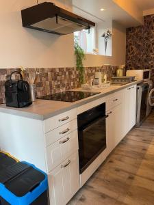 a kitchen with white cabinets and a stove top oven at Vert Bocage à Bâlines in Balines