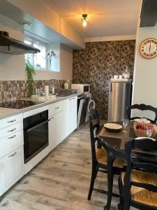 a kitchen with a table and chairs and a kitchen with a stove at Vert Bocage à Bâlines in Balines