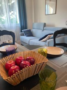 a bowl of apples on a table in a living room at Vert Bocage à Bâlines in Balines