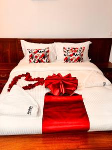 a white bed with red bows on top of it at NAIBERi LUXURY HOME in Eldoret