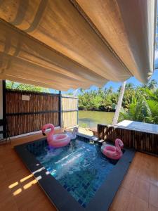 a swimming pool with three pink flamingos in it at Phetra pool villas in Suratthani