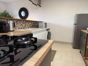 a kitchen with a black stove and a refrigerator at Grand T3 2 chambres avec vue sur la campagne à Bâlines in Balines