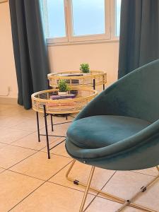 a living room with a chair and two tables at Grand T3 2 chambres avec vue sur la campagne à Bâlines in Balines