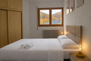 a bedroom with a bed with two towels on it at Apto Espert l PISCINA l Cine l Garaje l BBQ l Wifi in Biescas