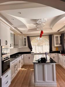 a kitchen with white cabinets and a black counter top at NAIBERi LUXURY HOME in Eldoret
