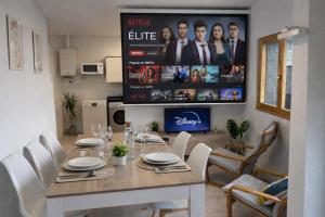 a dining room with a table and a tv at Apto Espert l PISCINA l Cine l Garaje l BBQ l Wifi in Biescas