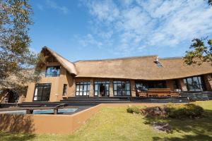 a large house with a thatched roof at Castle View in Pretoria