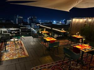 a restaurant with tables and chairs on a rooftop at night at Lao Poet Hotel in Vientiane