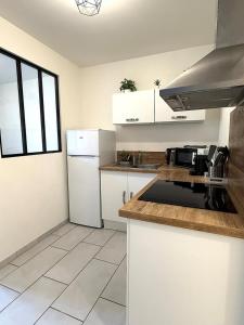 a kitchen with white cabinets and a white refrigerator at Appart' Lumineux & Chic. Parking Rue Sans Stress in Dreux +5 photos