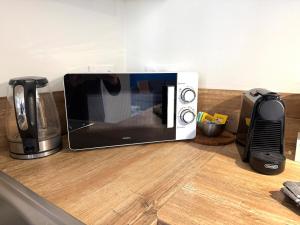 a microwave sitting on top of a counter at Appart' Lumineux & Chic. Parking Rue Sans Stress in Dreux