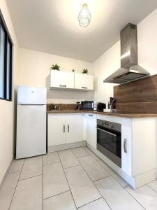 a kitchen with white cabinets and a stove at Appart' Lumineux & Chic. Parking Rue Sans Stress in Dreux