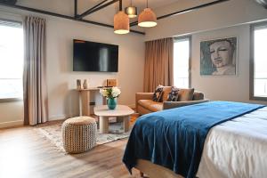 a bedroom with a bed and a living room at Walnut Bistro & Suites in Eymet