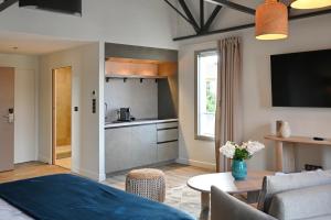 a living room with a table and a kitchen at Walnut Bistro & Suites in Eymet