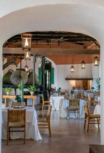 a dining room with white tables and chairs at Hotel Corbella in Posadas