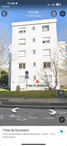 a white building with a sign in front of it at Studio Mulhouse in Mulhouse