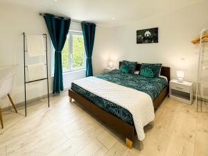 a bedroom with a bed with blue curtains and a window at Gîte Chez Claudia in Marsolan