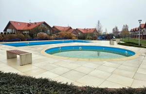a swimming pool with a bench in a courtyard at Łebska Ostoja - Zacisze in Żarnowska