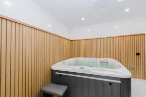 a jacuzzi tub in a room with wooden walls at Rawson Retreat - Spa, EV outlet and Premium Luxury in Jindabyne