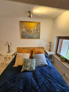a bedroom with a bed with blue sheets and pillows at Łebska Ostoja - Zacisze in Żarnowska +6 photos