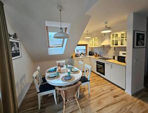a kitchen and dining room with a table and chairs at Łebska Ostoja - Zacisze in Żarnowska