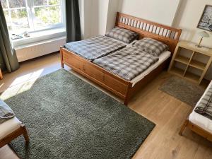 a bedroom with a bed and a rug at Penzion WIESEN in Meziměstí